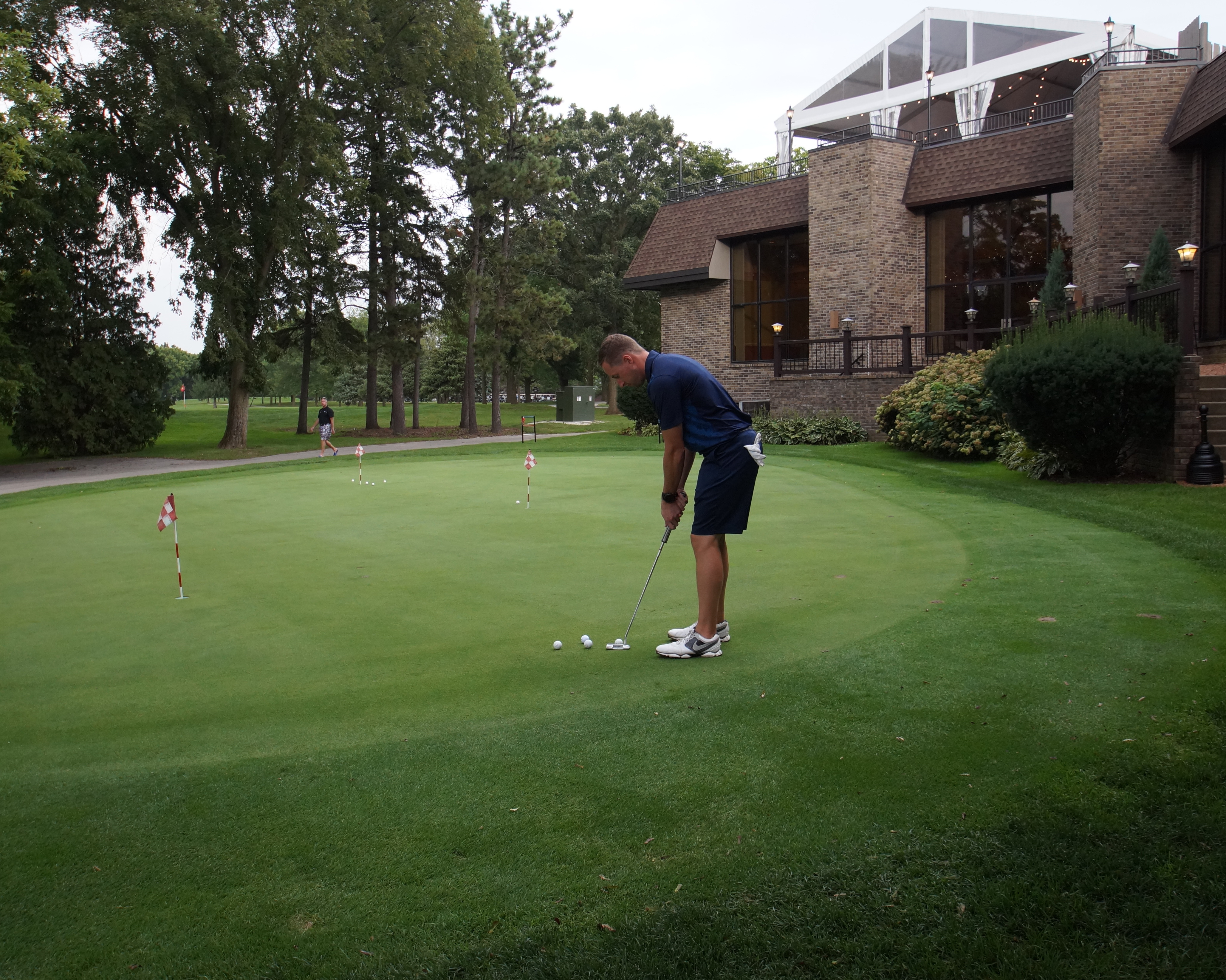 A man stands ready to putt on the putting green.